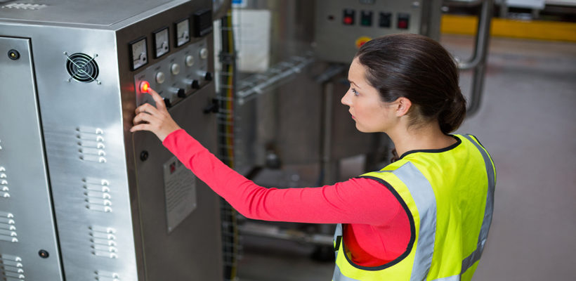 Female factory worker operating machine