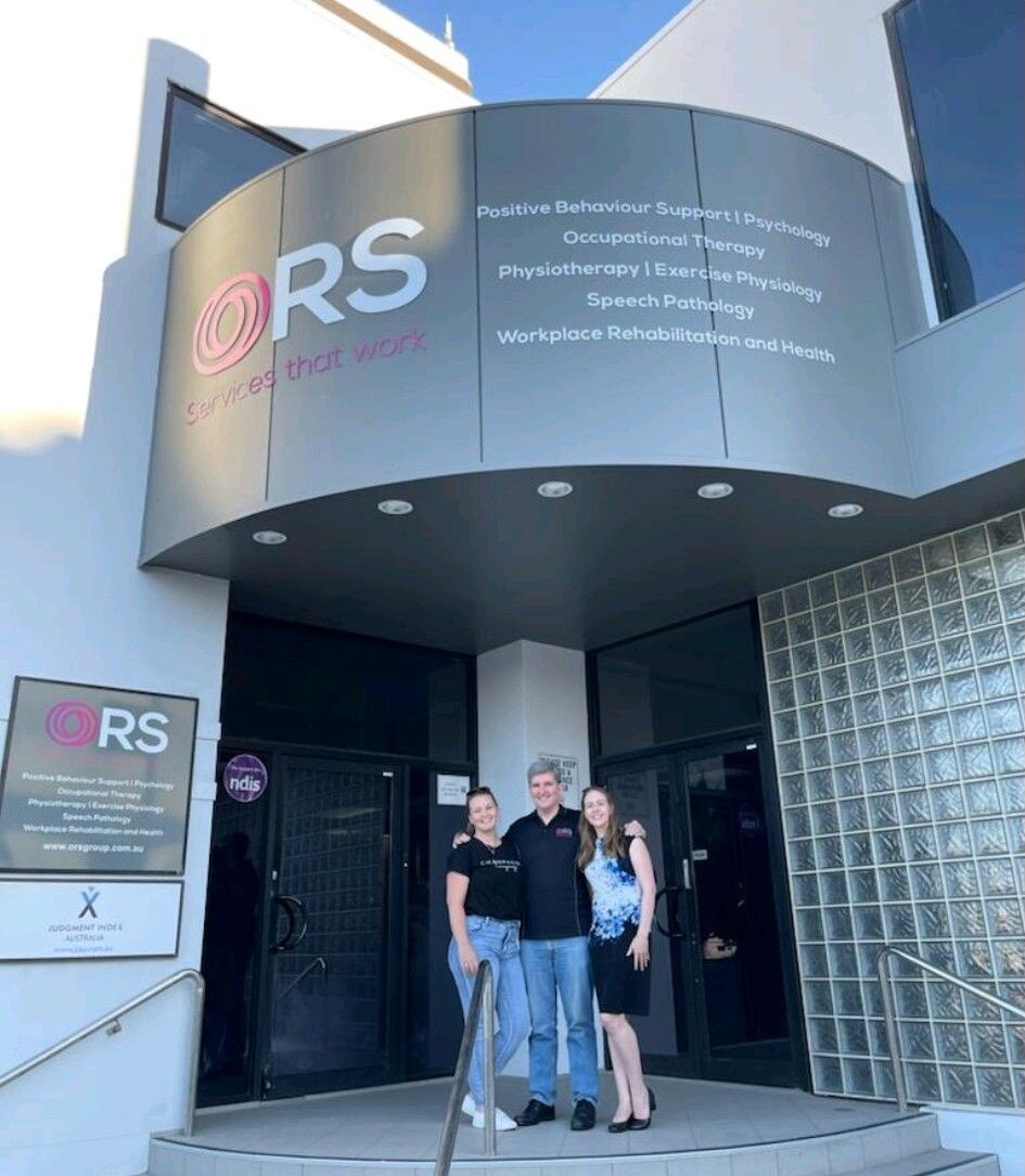 Peter Scott, owner and chairman of ORS, standing with his two daughters in front of an ORS office.