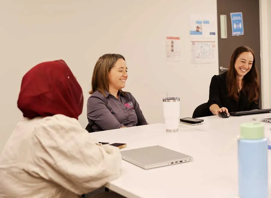 Clinicians smiling and chatting in a group huddle