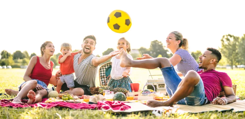 family-at-picnic-eating-healthy-and-playing-with-ball