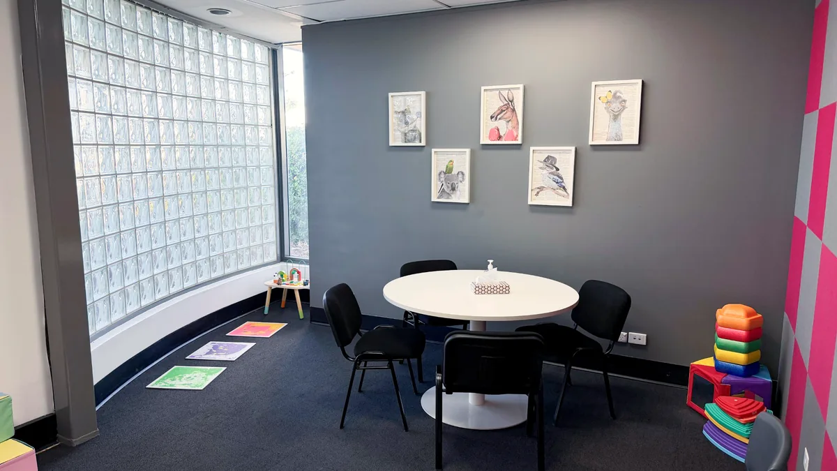 Paediatric room with a round table, sensory floor tiles and colourful animal artwork at ORS Fyshwick