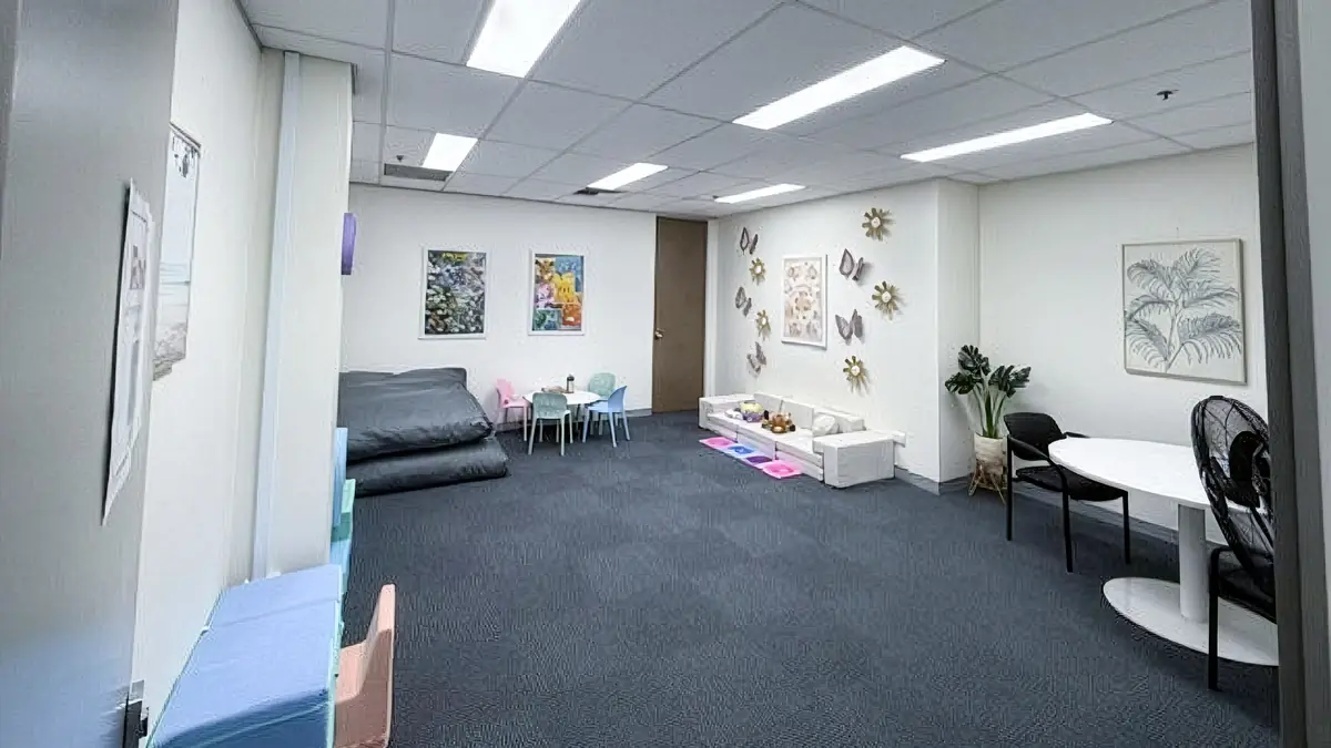 Large wheelchair accessible paediatric therapy room with soft play furniture, children's tables and sensory floor tiles at ORS Gosford