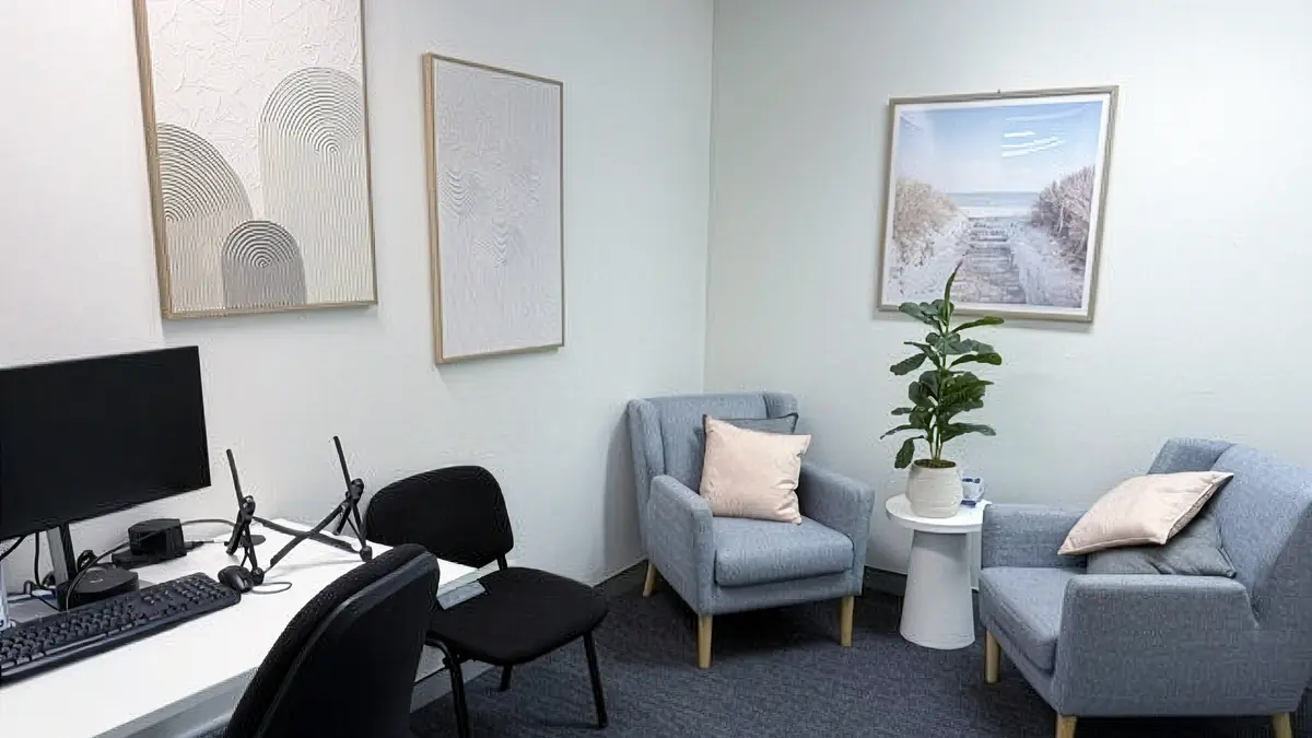 Private counselling room with two armchairs, a side table and a clinician desk at ORS Gosford