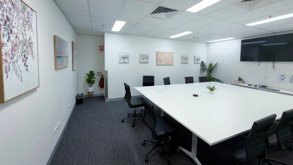 Training room with a large meeting table, office chairs and a wall-mounted screen at ORS Gosford