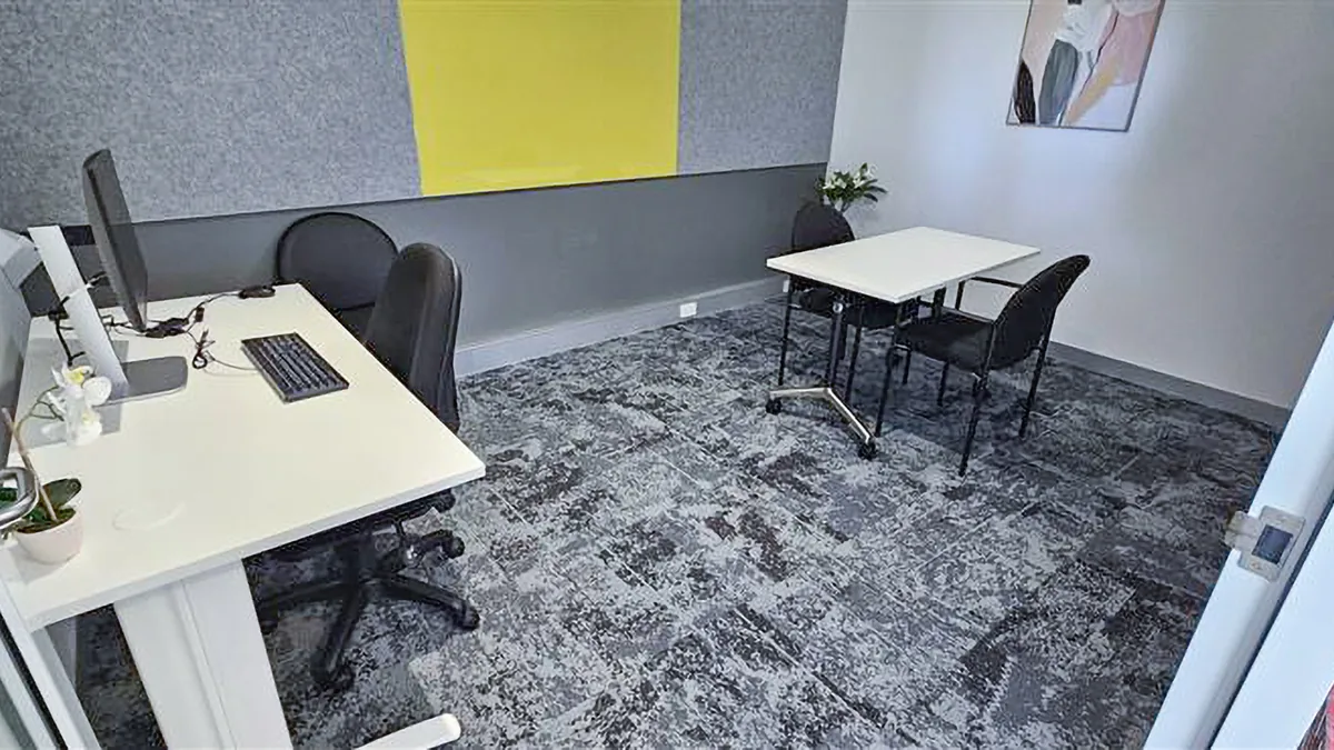 Assessment and consulting room with a small table, chairs and clinician desk at ORS Joondalup