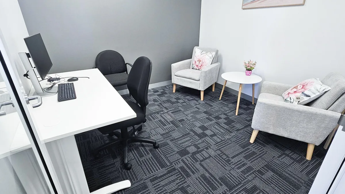 Consult and counselling room with a light grey lounge, armchair and side table at ORS Joondalup