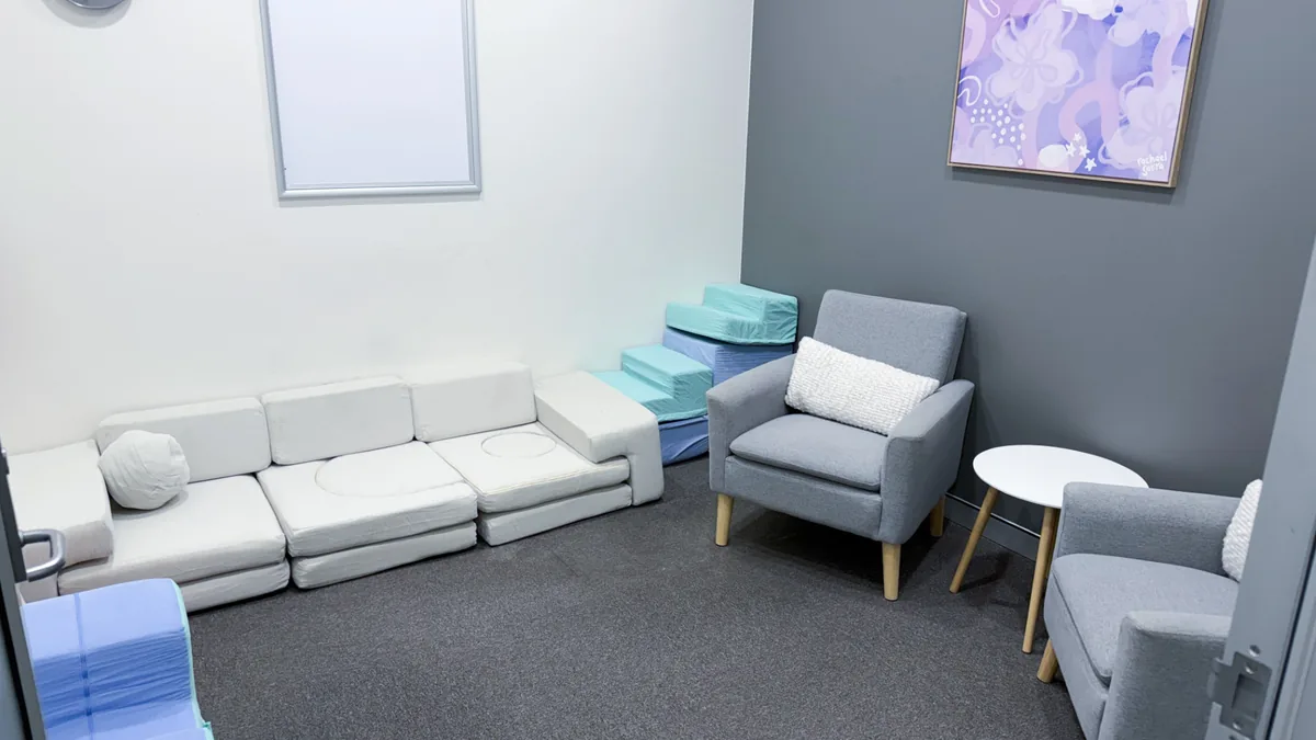 Accessible paediatric and counselling room with a soft play lounge, armchairs and side table at ORS Mandurah