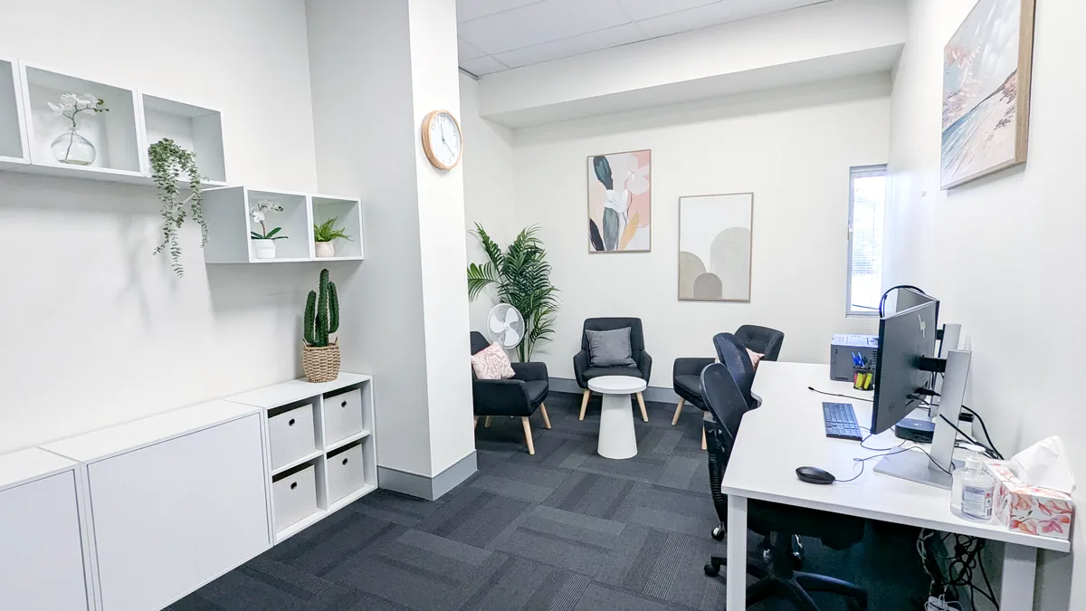 Accessible consult and counselling room with armchairs, a side table and clinician desk at ORS Mitchell