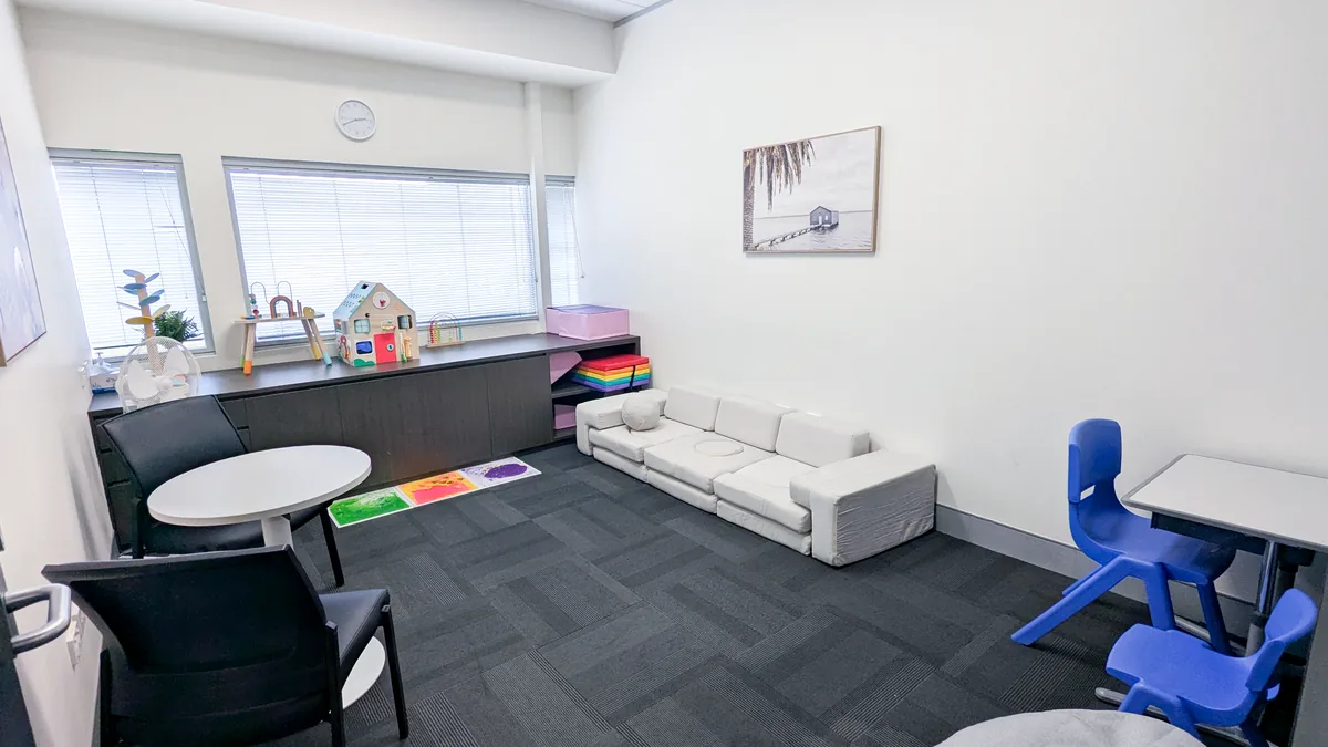 Accessible paediatric therapy room with a soft play lounge, sensory floor tiles, armchairs and toys at ORS Mitchell