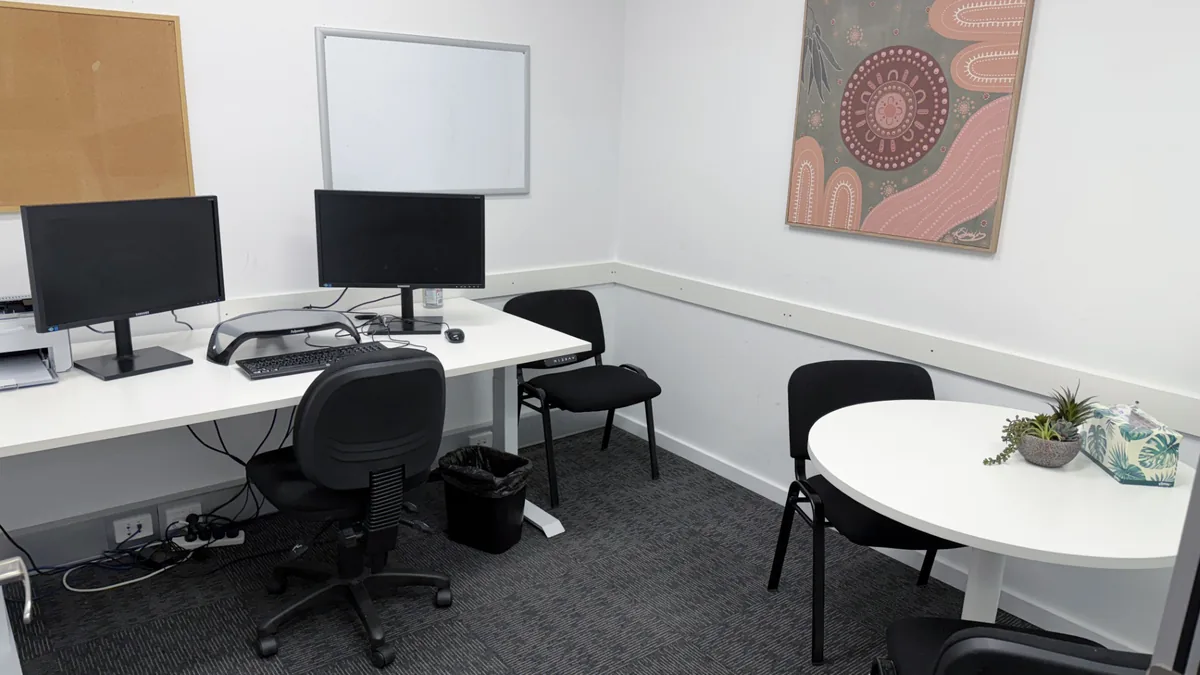Appointment room with a round table, clinician desk and a patterned artwork at ORS Morley