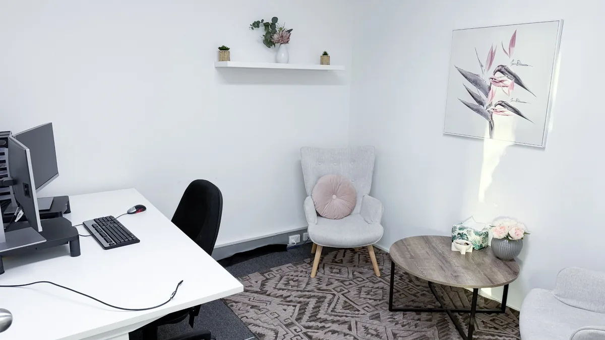 Accessible counselling room with two armchairs, a coffee table and patterned rug at ORS Morley