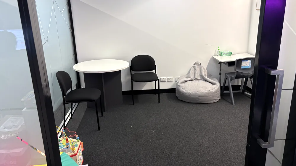 Paediatric therapy room with a round table, beanbag, child's desk and play equipment at ORS Mount Waverley