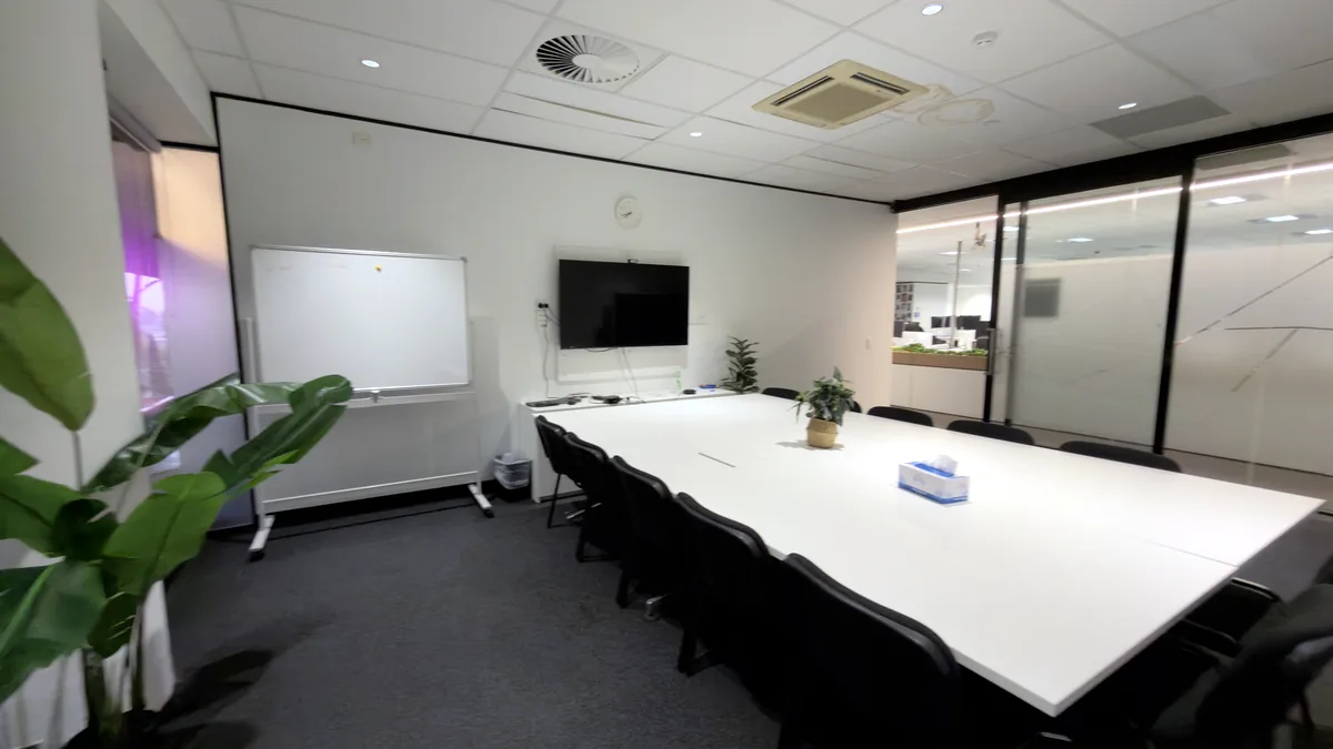 Training room with a large meeting table, chairs, whiteboard and wall-mounted screen at ORS Mount Waverley