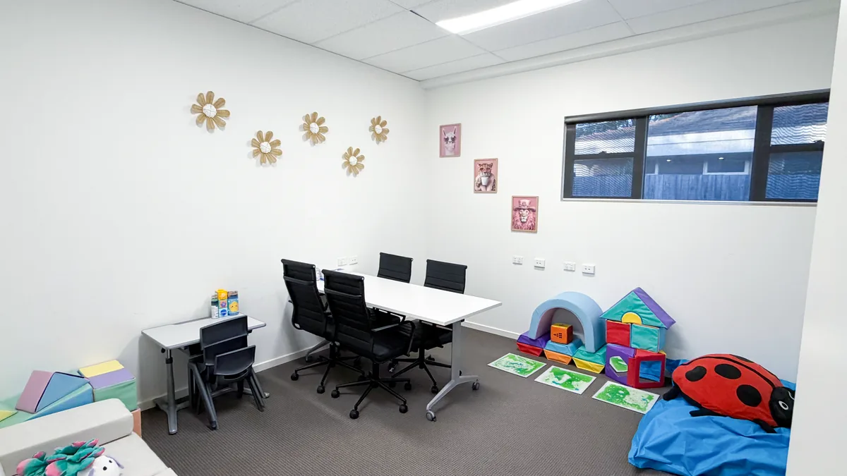 Paediatric therapy room with soft play blocks, a ladybug beanbag, sensory floor tiles and a child's desk at ORS Pakenham