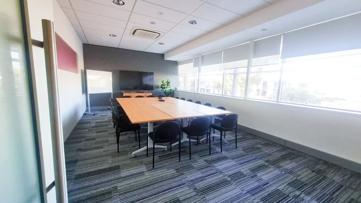 Accessible training and assessment room with a long boardroom table and large windows at ORS Stirling