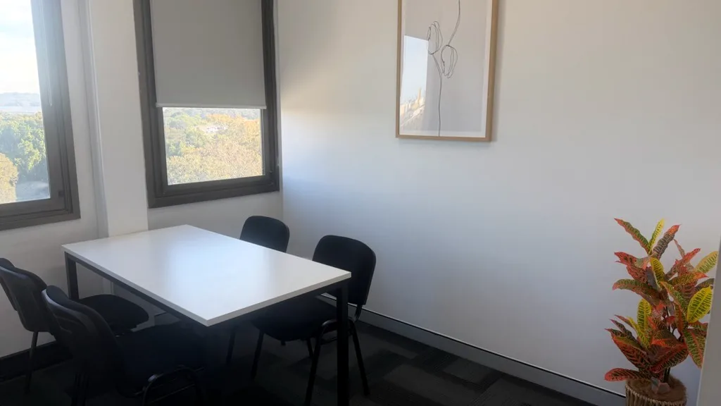 Consulting room with a white table, chairs, a line artwork and an indoor plant at ORS Wollongong
