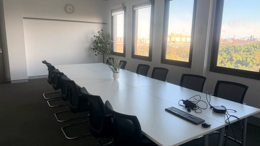 Training room with a long meeting table, chairs and a row of windows at ORS Wollongong